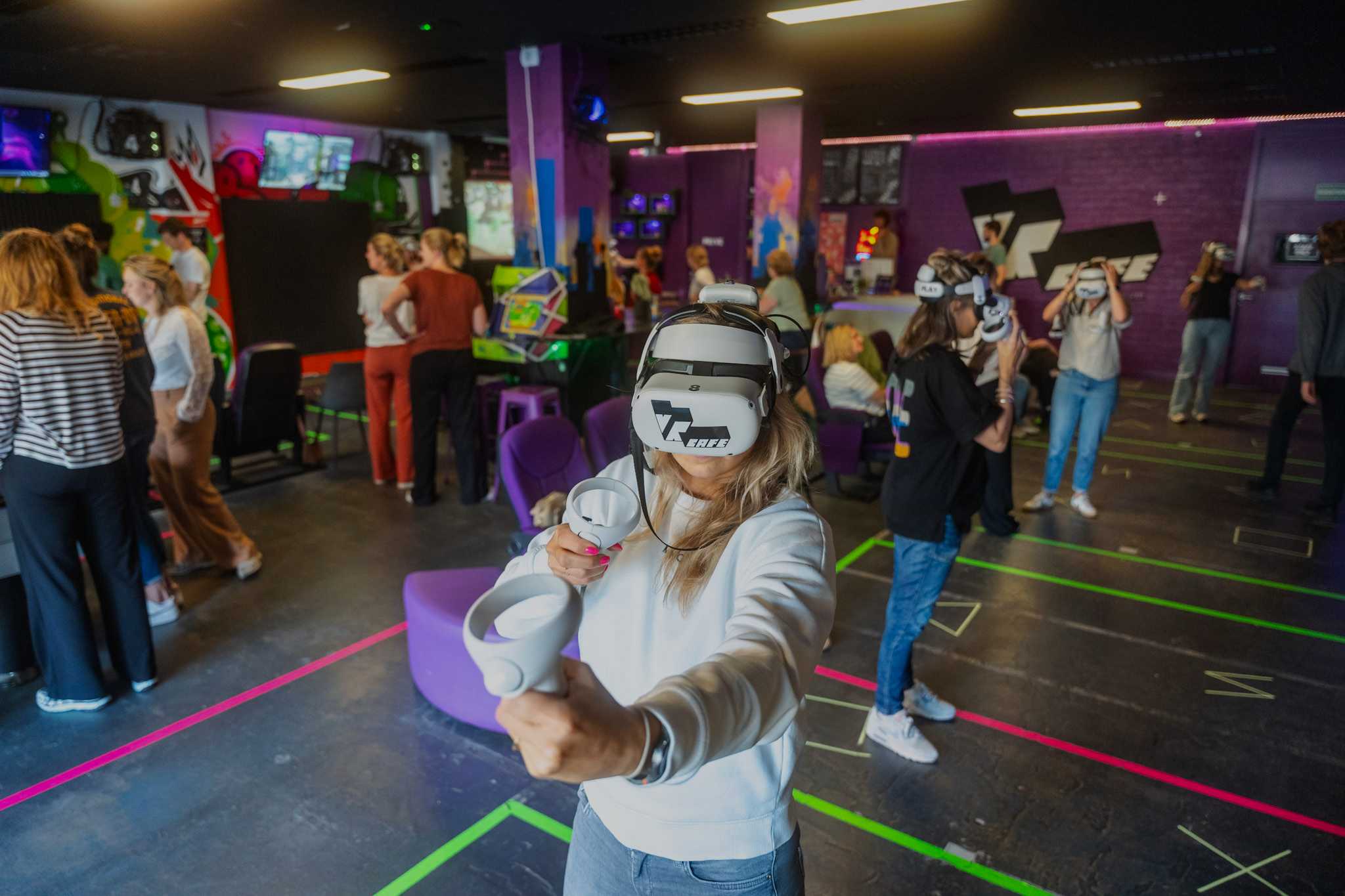 A big group of people playing VR, arcade games and having fun in VRcafe Haarlem